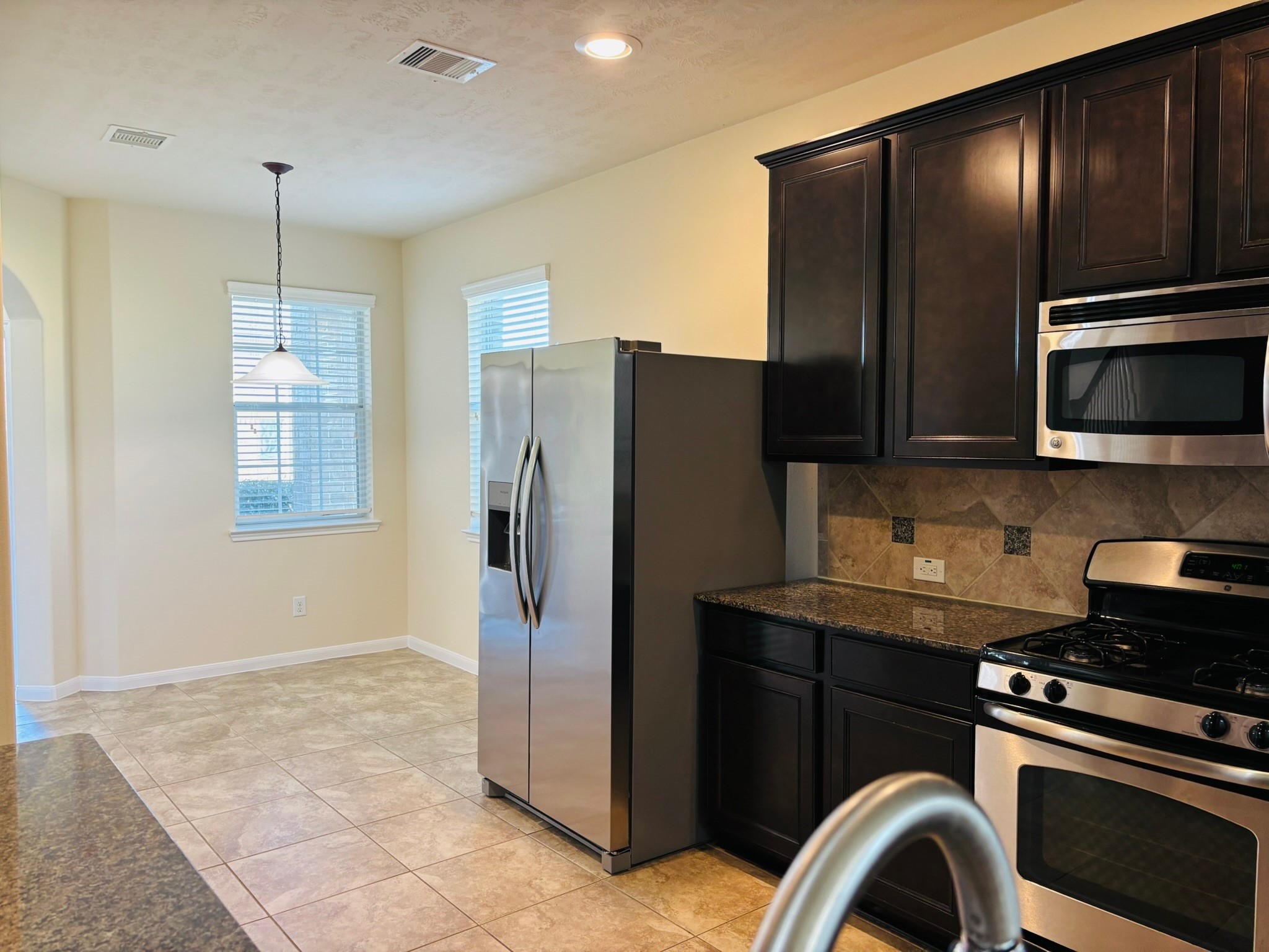 8525 Sunset Loch Drive Spring, TX 77379 - Photo 6 of 24 a kitchen with stainless steel appliances granite countertop a refrigerator and a stove top oven