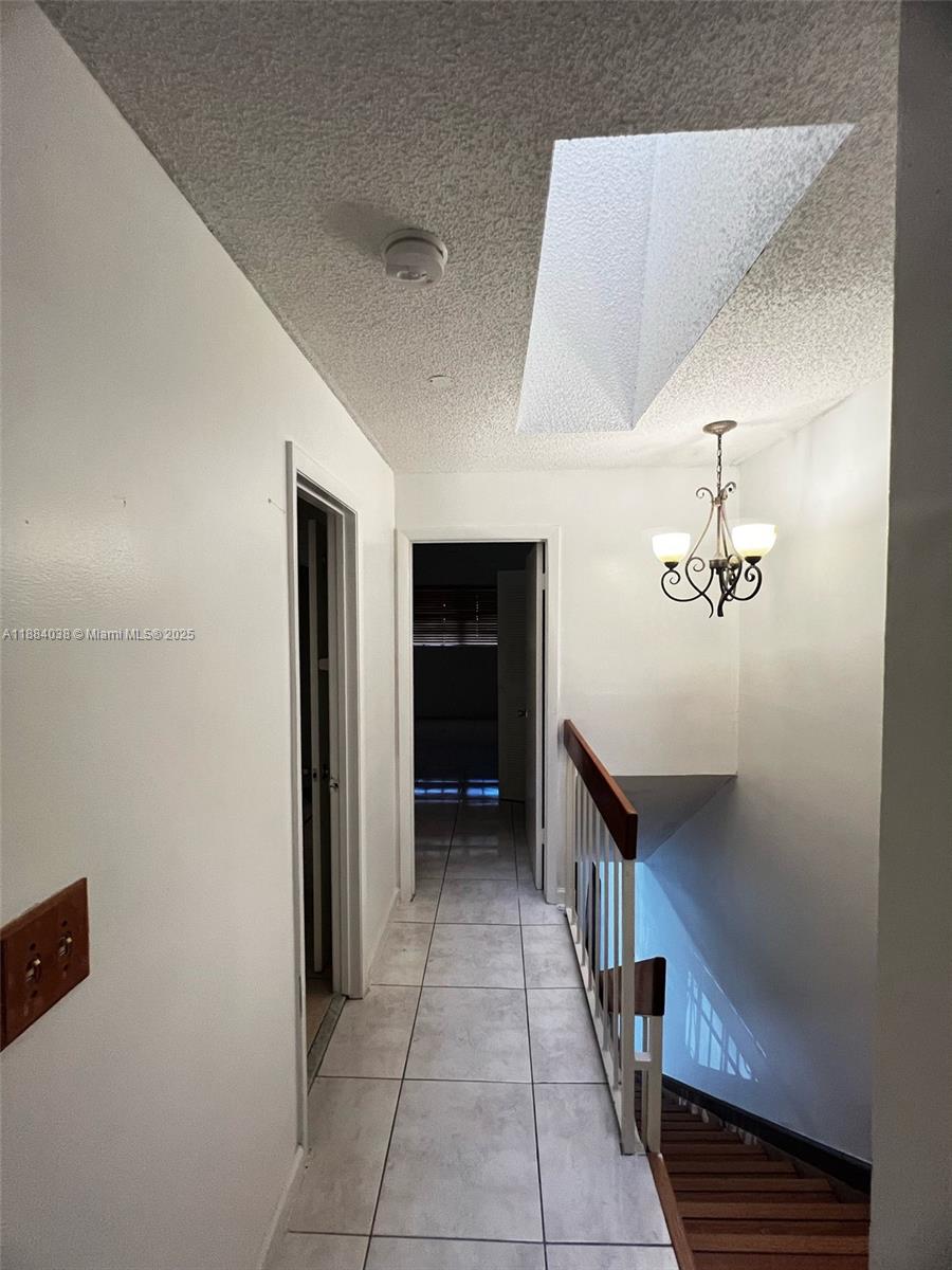 13345 Southwest 59th Lane Miami, FL 33183 - Photo 16 of 29 a hallway with windows and chandelier