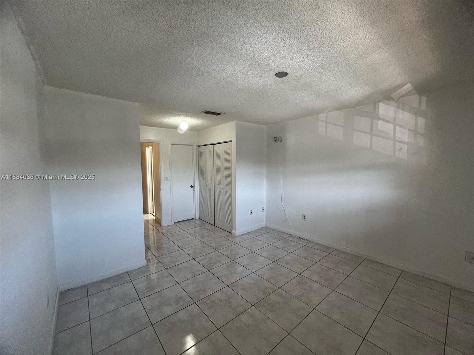 13345 Southwest 59th Lane Miami, FL 33183 - Photo 19 of 29 an empty room with white walls and tiles