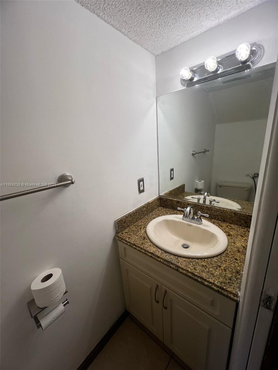13345 Southwest 59th Lane Miami, FL 33183 - Photo 6 of 29 a bathroom with a granite countertop sink a mirror and shower