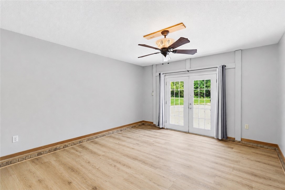941 Scotland Road Easley, SC 29640 - Photo 17 of 25 French doors open to outdoor space, complemented by wide plank flooring and a ceiling fan.
