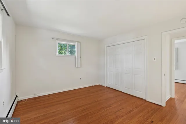 a view of empty room with wooden floor