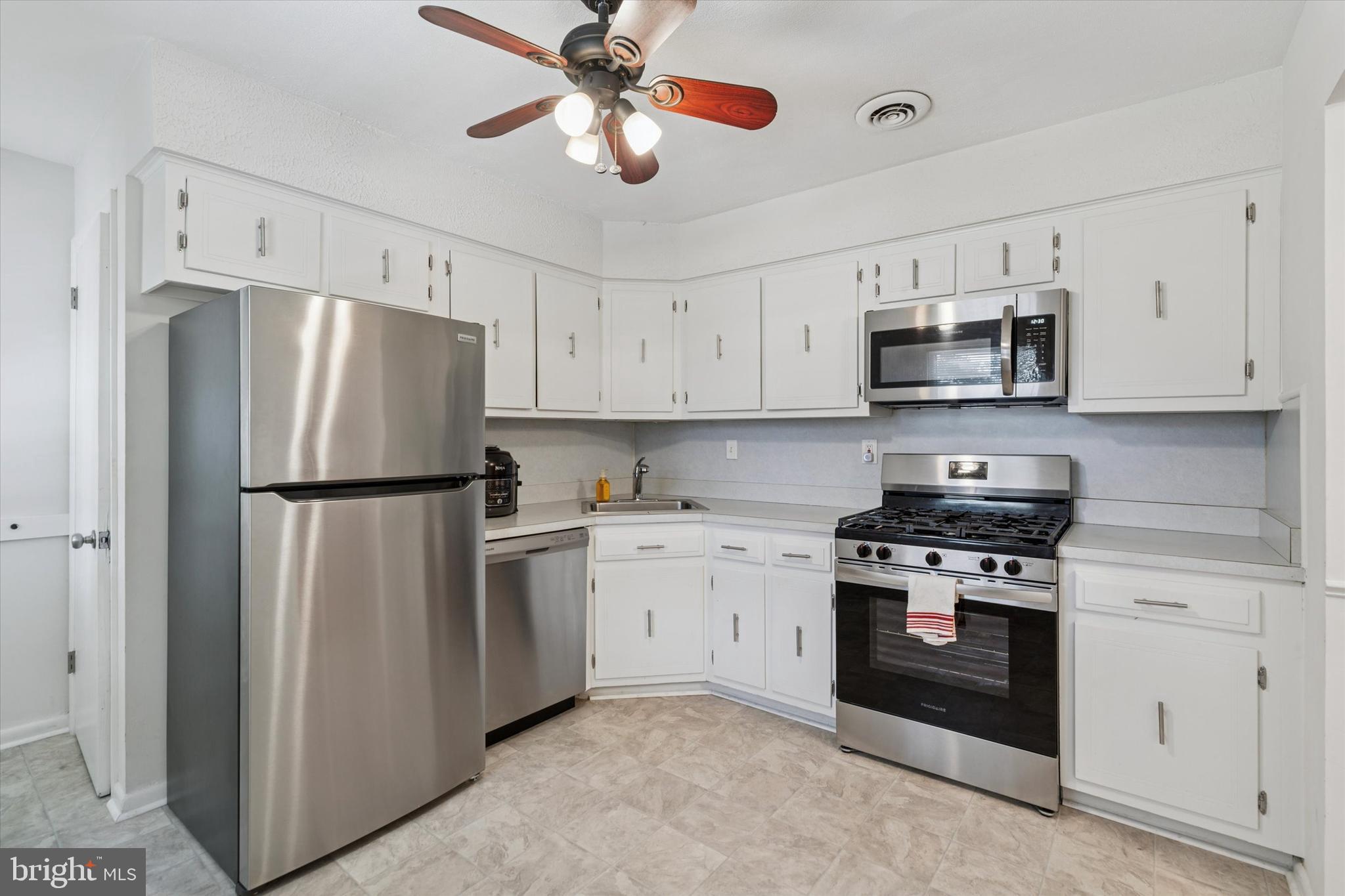 1948 Lukens Avenue Willow Grove, PA 19090 - Photo 8 of 23 a kitchen with stainless steel appliances granite countertop a refrigerator a stove a microwave oven with white cabinets