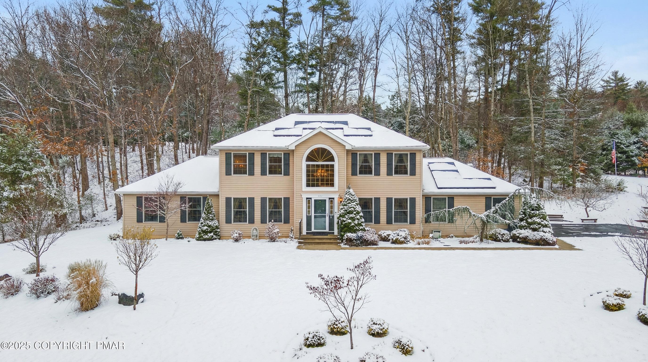 a front view of a house with a yard covered with snow