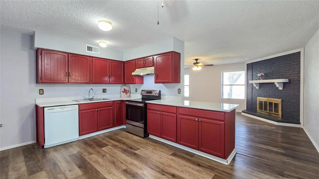 1526 Toyah Creek Lane Garland, TX 75040 - Photo 5 of 10 a kitchen with stainless steel appliances granite countertop a sink dishwasher stove and wooden cabinets