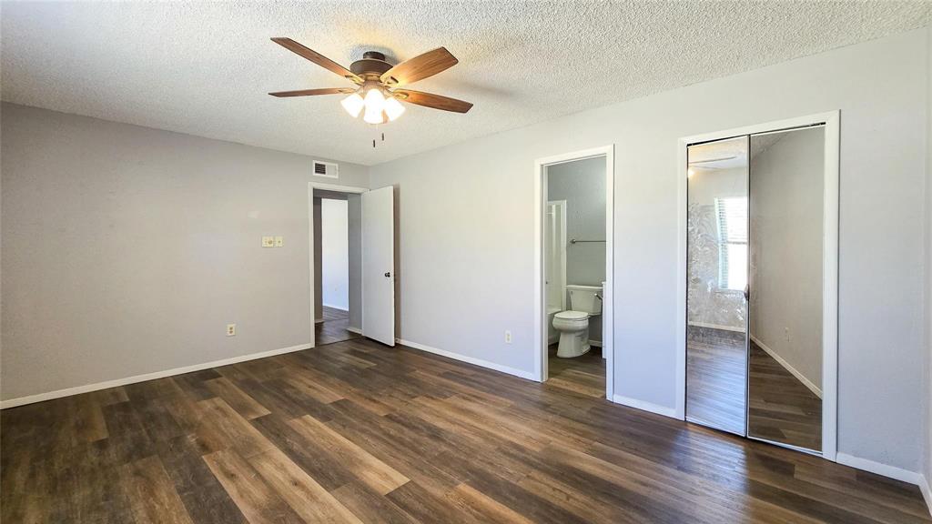 1526 Toyah Creek Lane Garland, TX 75040 - Photo 8 of 10 an empty room with wooden floor and a ceiling fan