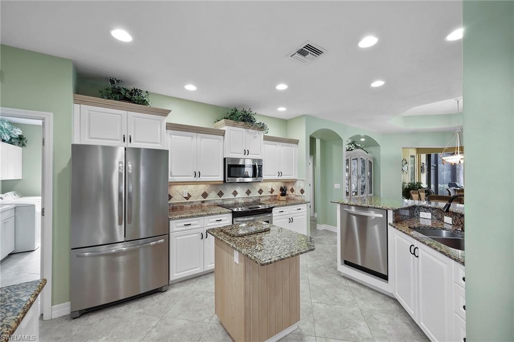 8862 Lely Island Circle Naples, FL 34113 - Photo 13 of 47 a kitchen with stainless steel appliances granite countertop a stove and a refrigerator