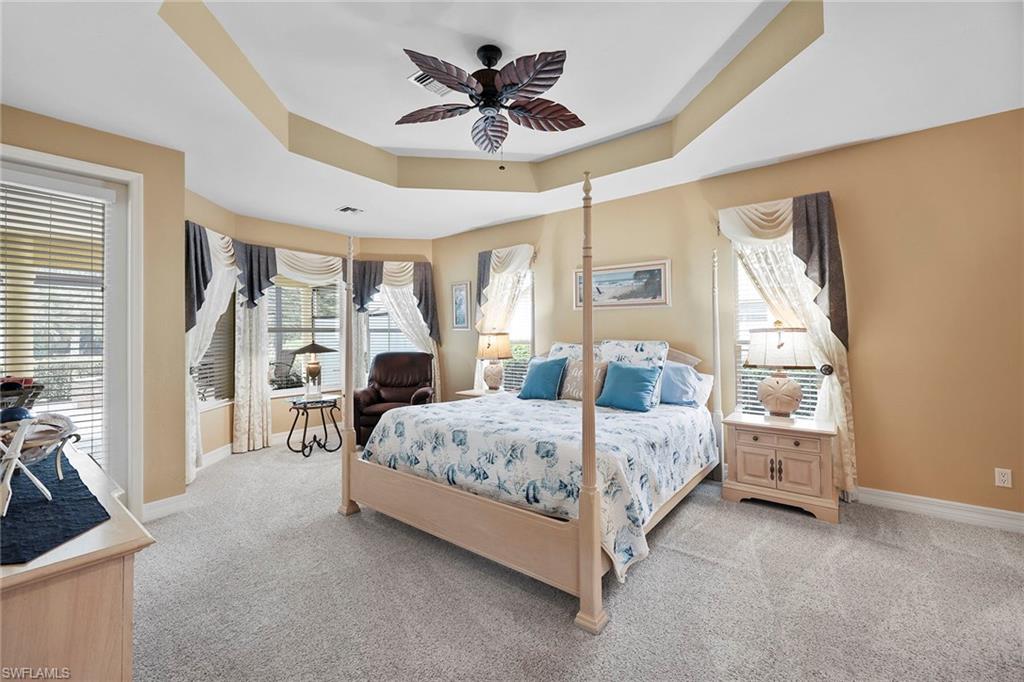 8862 Lely Island Circle Naples, FL 34113 - Photo 15 of 47 a bedroom with a bed and a chandelier