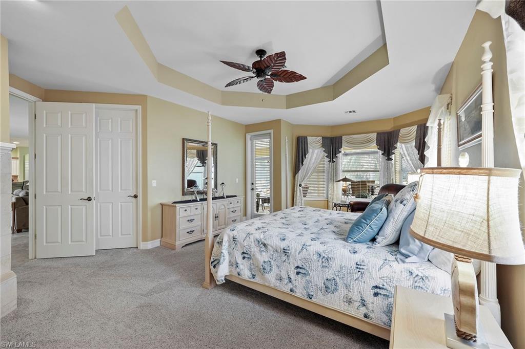 8862 Lely Island Circle Naples, FL 34113 - Photo 16 of 47 a bedroom with a large bed a flat tv screen and dresser