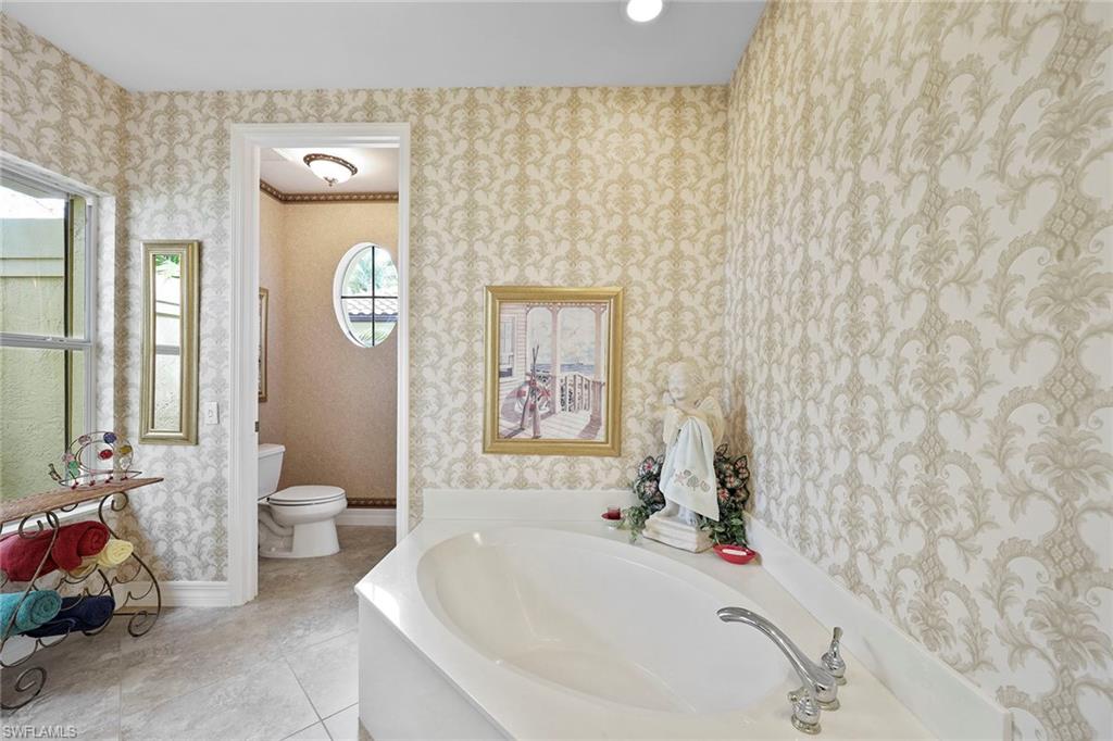 8862 Lely Island Circle Naples, FL 34113 - Photo 19 of 47 a bathroom with a sink a toilet and a tub