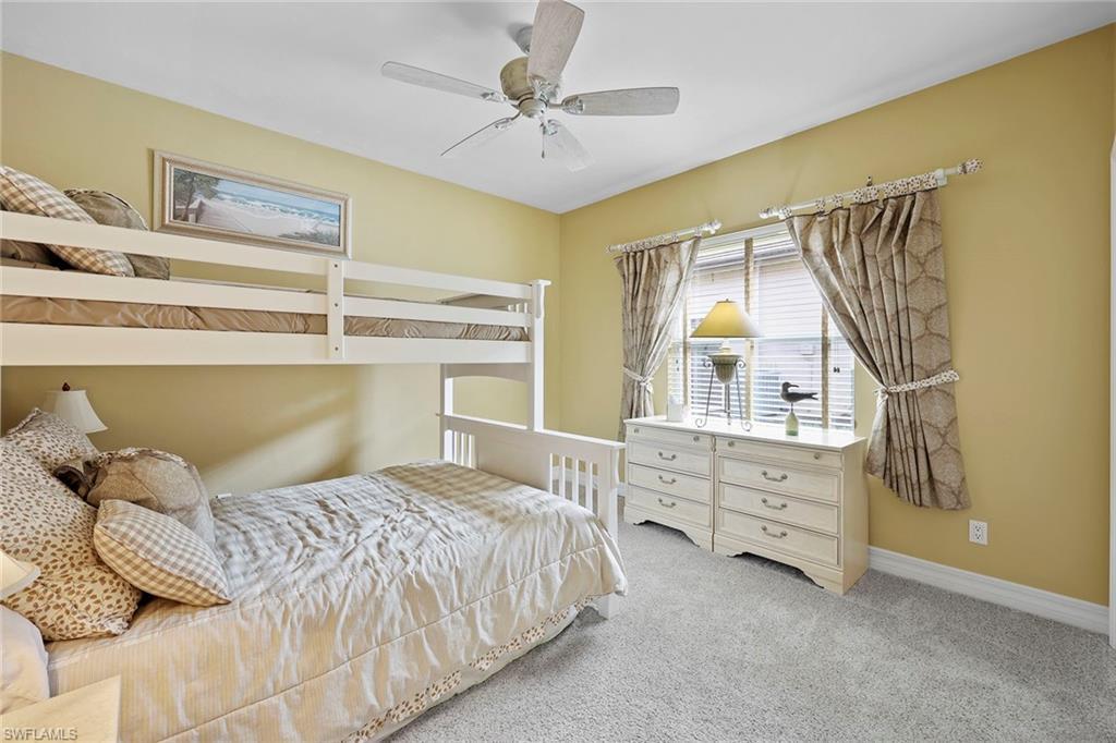 8862 Lely Island Circle Naples, FL 34113 - Photo 20 of 47 a bedroom with a bed and a chandelier