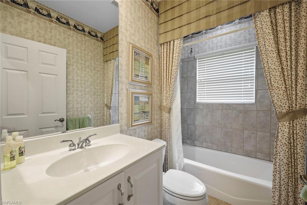 8862 Lely Island Circle Naples, FL 34113 - Photo 21 of 47 a bathroom with a bathtub shower sink vanity mirror and toilet