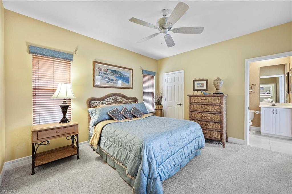 8862 Lely Island Circle Naples, FL 34113 - Photo 22 of 47 a bedroom with a bed and a chandelier