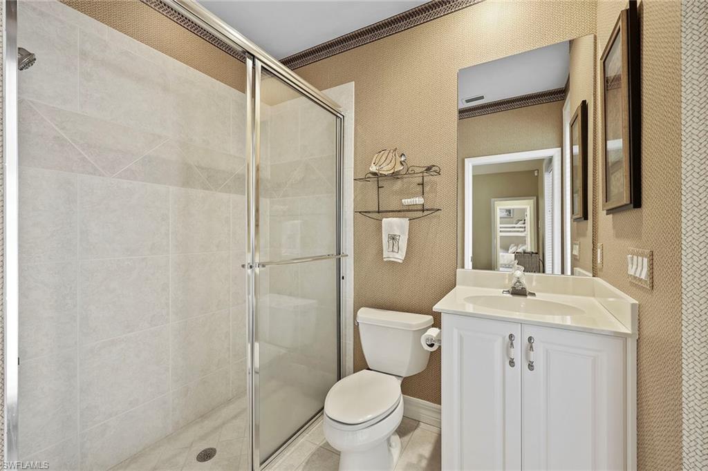 8862 Lely Island Circle Naples, FL 34113 - Photo 23 of 47 a bathroom with a granite countertop sink toilet and shower