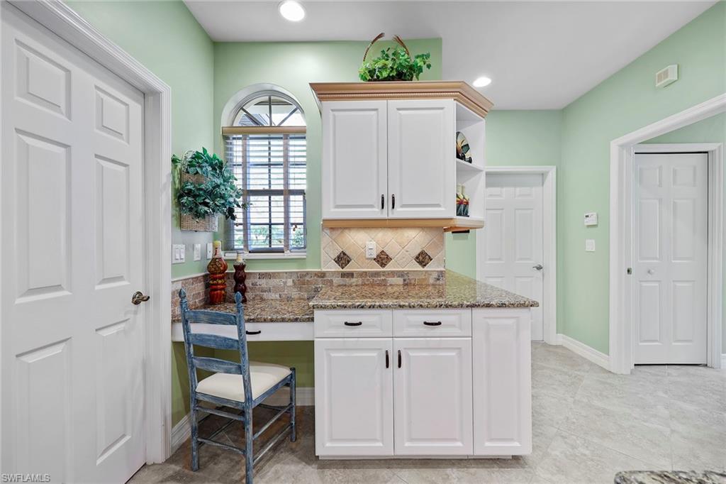 8862 Lely Island Circle Naples, FL 34113 - Photo 24 of 47 a kitchen with cabinets and chairs in it