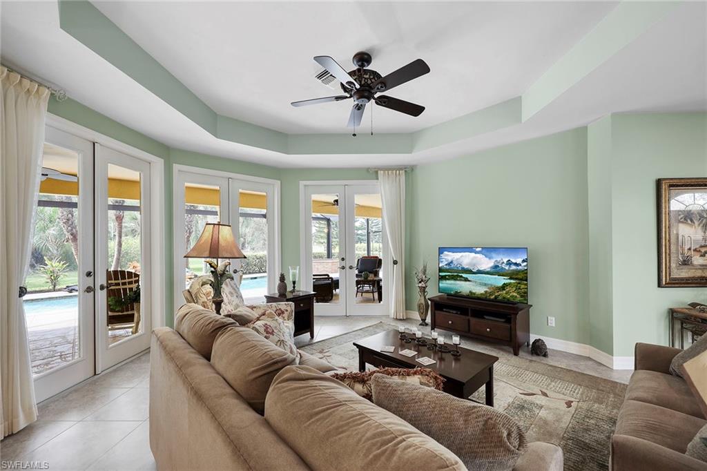8862 Lely Island Circle Naples, FL 34113 - Photo 5 of 47 a living room with furniture a floor to ceiling window and a flat screen tv