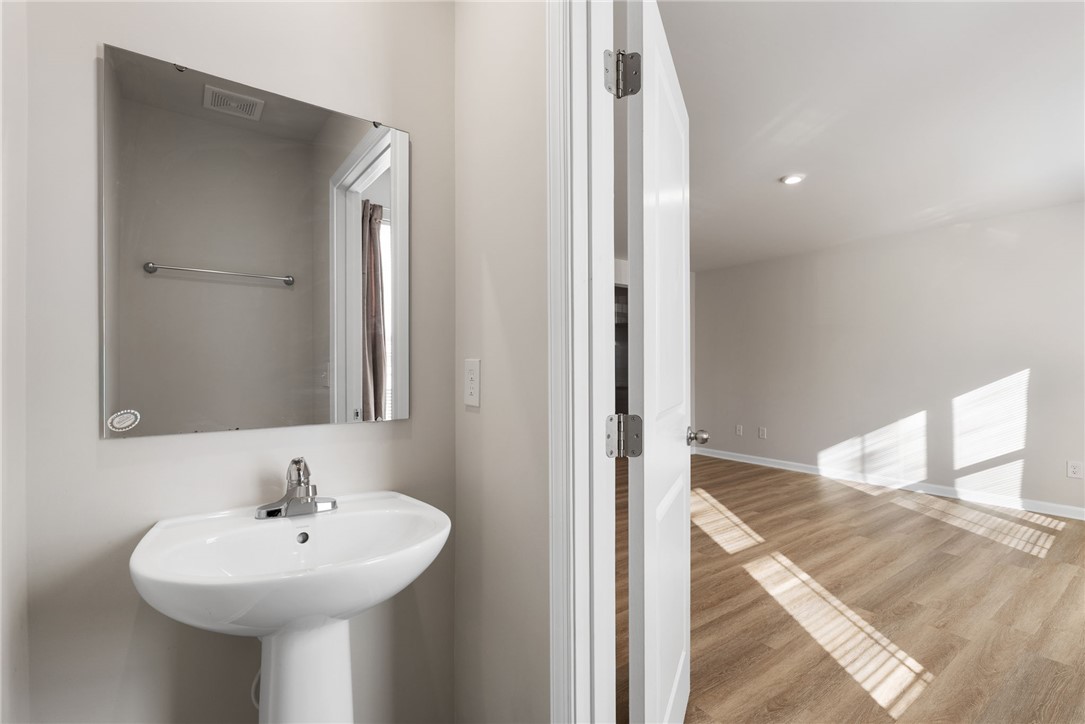 109 Brooklane Court Easley, SC 29642 - Photo 14 of 47 This modern bathroom features a sleek pedestal sink and wood flooring, offering both style and functionality.