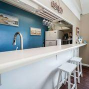 7998 East County Highway 30A, Unit 7 Inlet Beach, FL 32461 - Photo 11 of 16 a kitchen with stainless steel appliances granite countertop a sink and cabinets