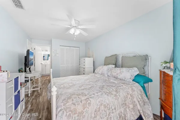 a bedroom with a bed and a flat tv screen on the dresser