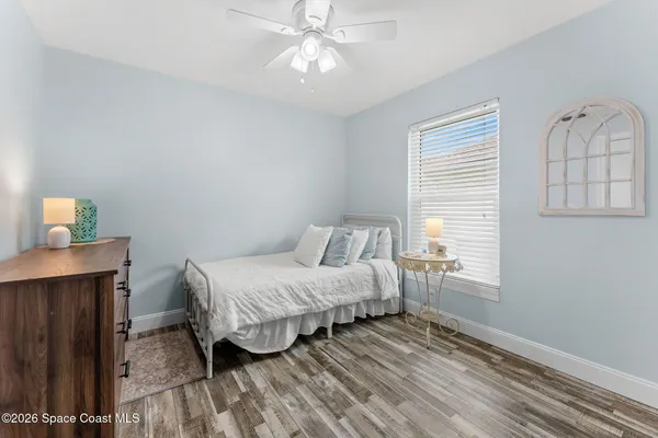 a bedroom with a bed wooden floor and window