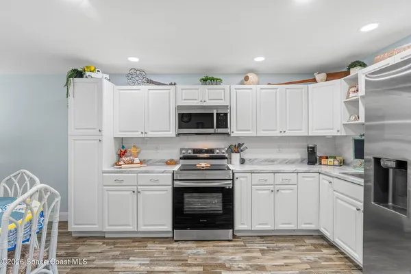 a kitchen with stainless steel appliances granite countertop a stove and white cabinets