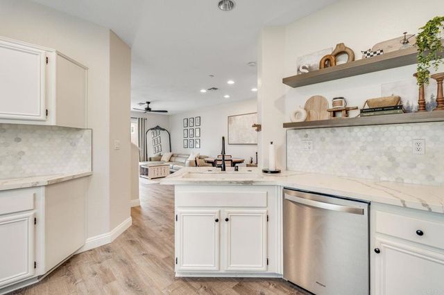 a kitchen with white cabinets and sink