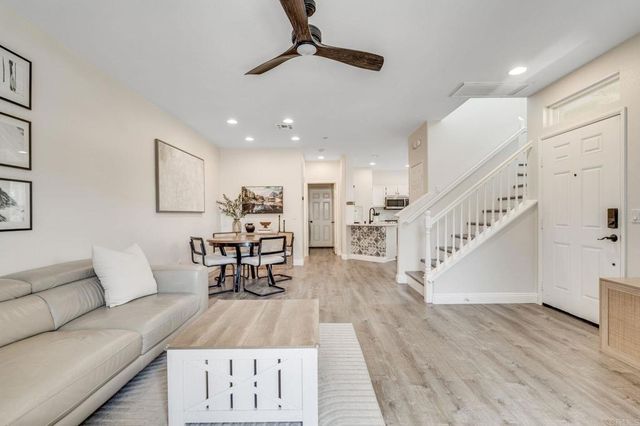 a living room with furniture and kitchen view