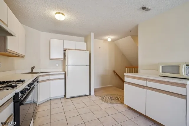 a kitchen with a stove cabinets and a refrigerator