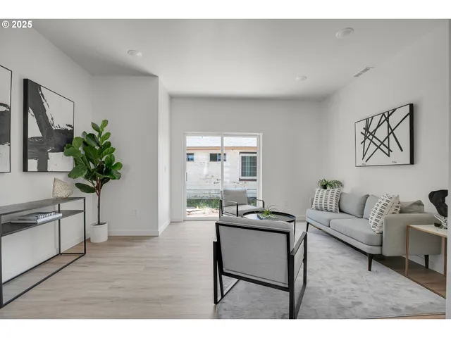 a living room with furniture potted plant and a window