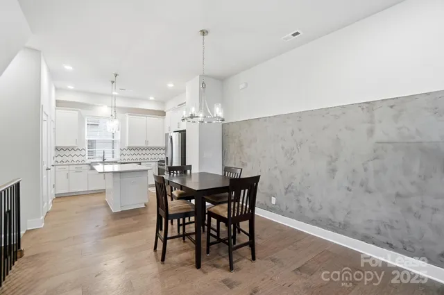 a view of a dining room and livingroom with furniture wooden floor a chandelier