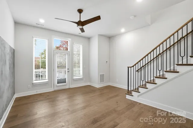 a dining room with wooden floor a chandelier a wooden table and chairs