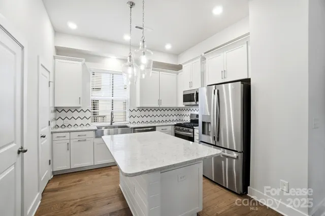a kitchen with stainless steel appliances a refrigerator sink and stove