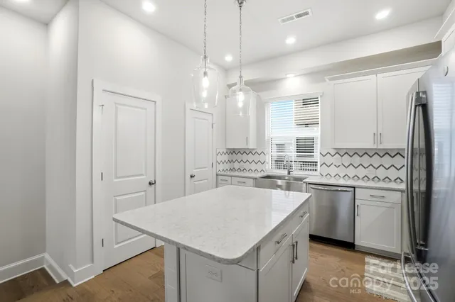 a kitchen with granite countertop a stove refrigerator and microwave