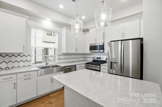 a kitchen with granite countertop a sink stainless steel appliances and cabinets