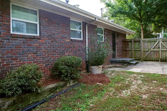 a backyard of a house with plants and large trees