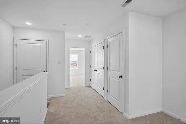 a view of a hallway with closet and bathroom
