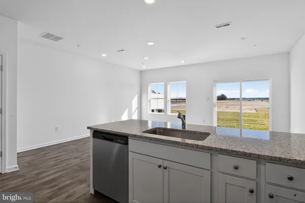 a kitchen with granite countertop a sink a stove and cabinets