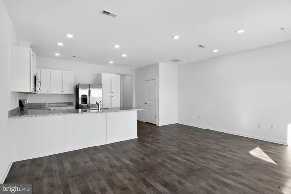 a large kitchen with stainless steel appliances a large counter top a stove a sink a refrigerator and a granite counter tops