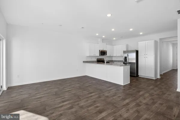 a view of kitchen with refrigerator and microwave