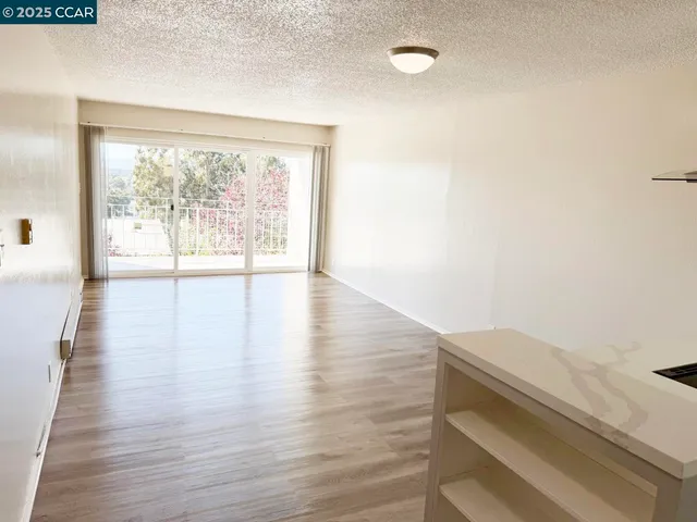 a view of an empty room and wooden floor