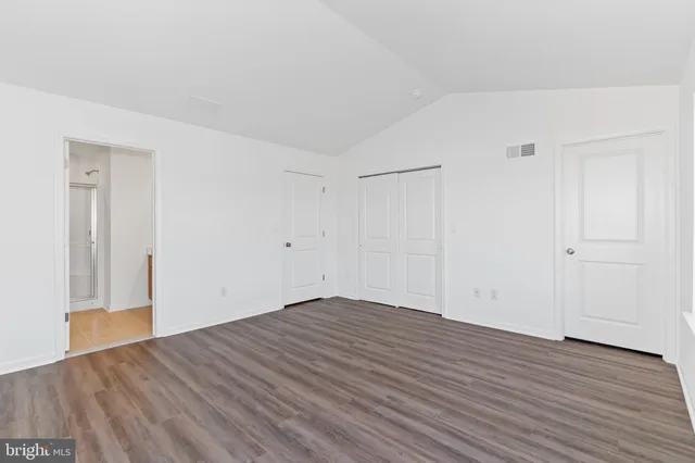 a view of an empty room with wooden floor