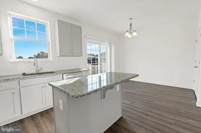a kitchen with stainless steel appliances granite countertop a sink a window and a counter space