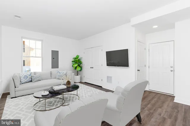 a living room with furniture a flat screen tv and a window