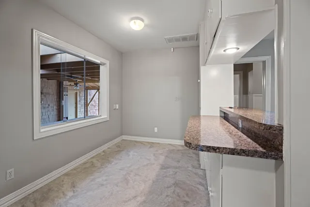 a bathroom with a granite countertop sink and washing machine