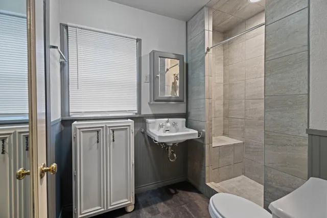 a bathroom with a sink a toilet and shower