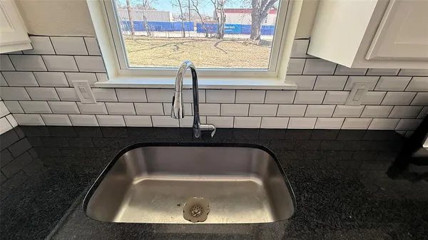a kitchen with a sink appliances and cabinets