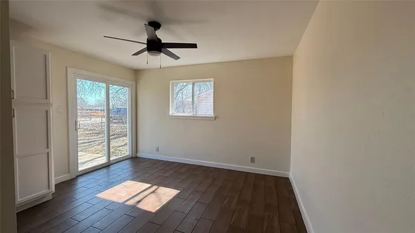 an empty room with a window and a ceiling fan