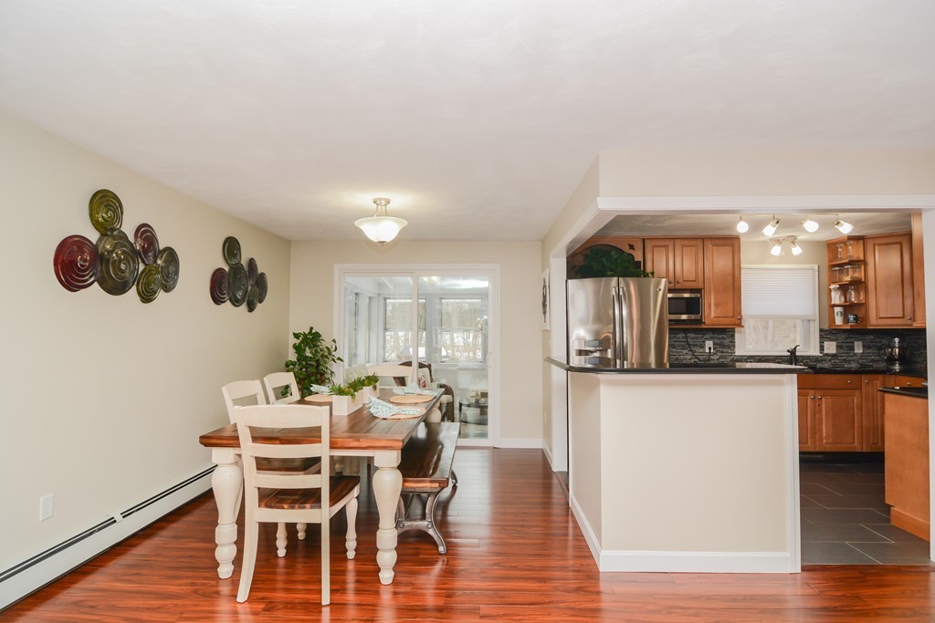 199 Center Bridge Road Lancaster, MA 01523 - Photo 7 of 30 a dining room with kitchen island stainless steel appliances furniture a kitchen view and wooden floor