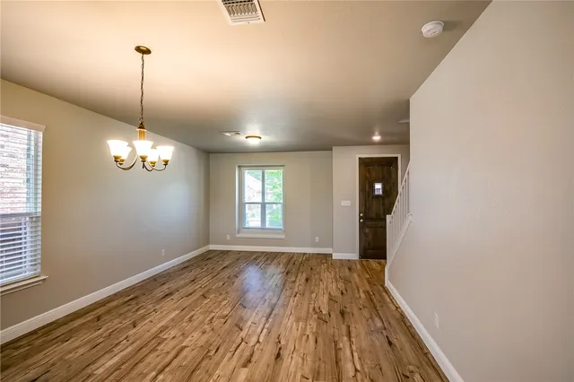 a view of a room with wooden floor and chandelier