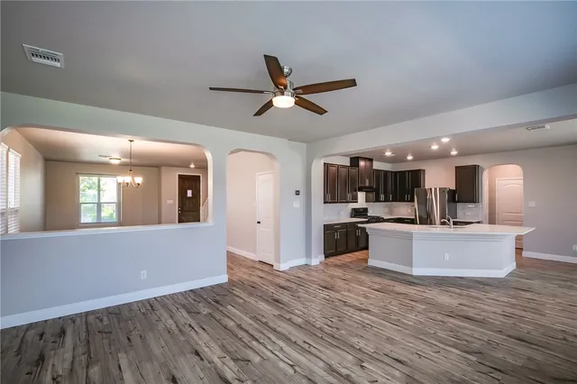a view of kitchen with sink microwave refrigerator and stove with wooden floor